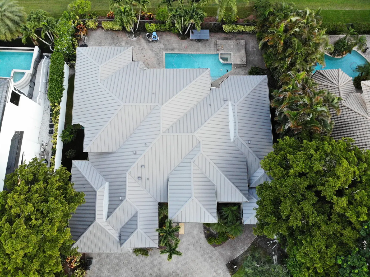 Aerial view of the same home with a completed standing-seam metal roof